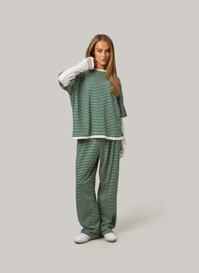 Woman wearing a green and white striped outfit on a gray background
