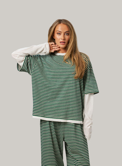 Woman wearing a green and white striped outfit on a gray background