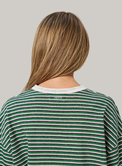 Person wearing a green and white striped shirt with 'Treat' branding on a plain background