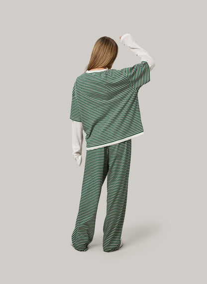 Person wearing a green and white striped outfit on a gray background