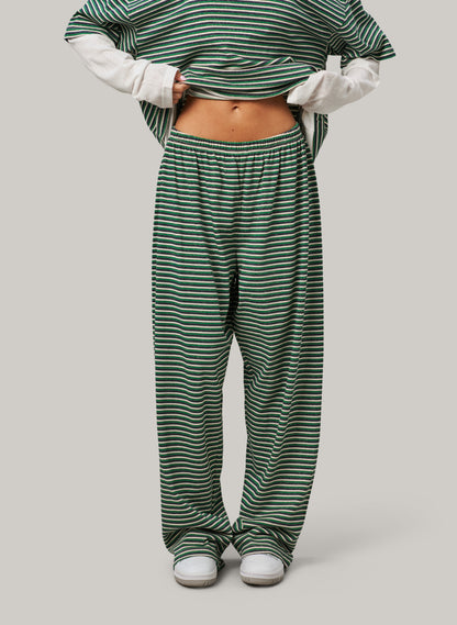 Person wearing green and white striped pants on a plain background