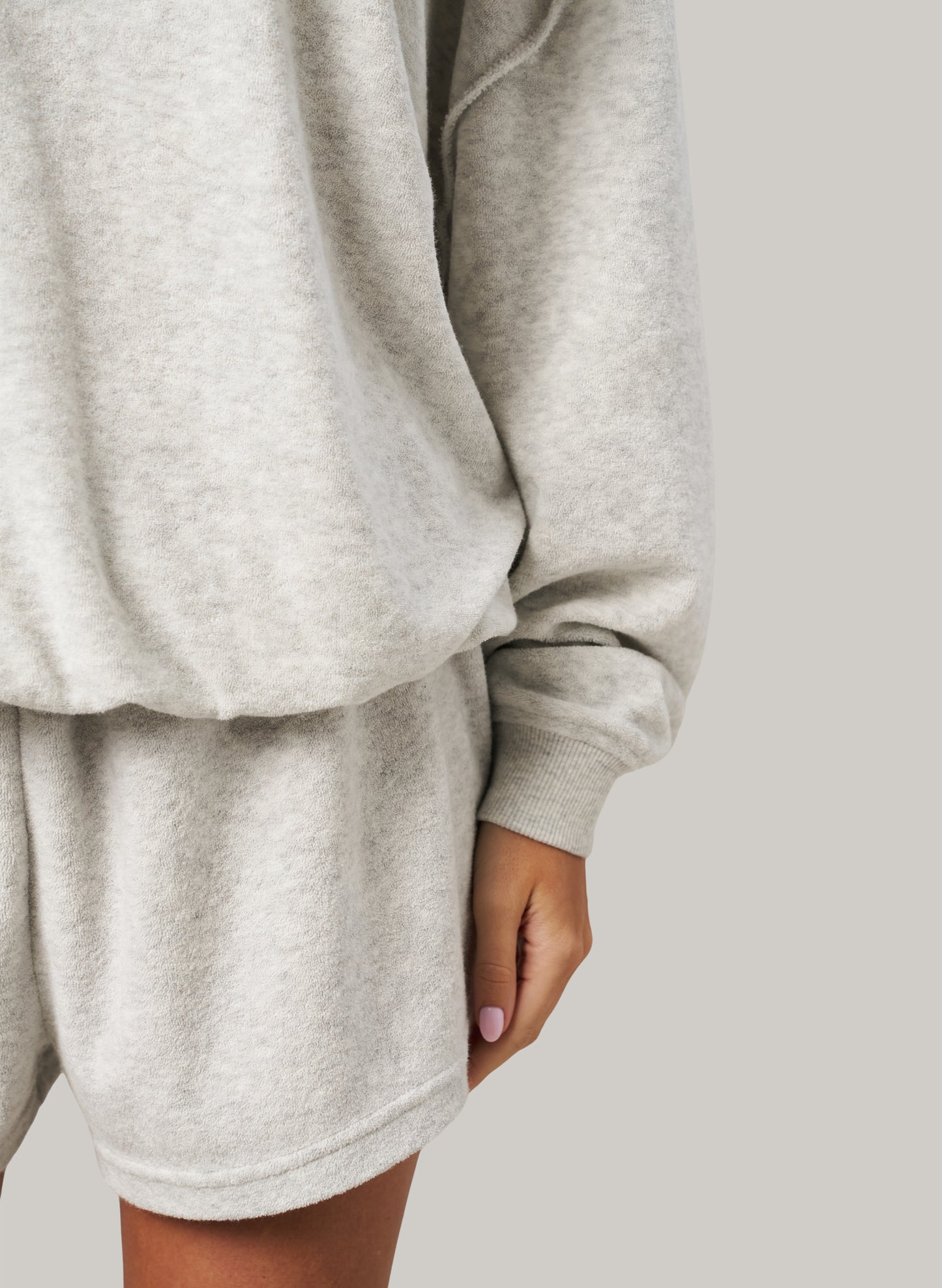 Grey sweatshirt and shorts set on a plain background