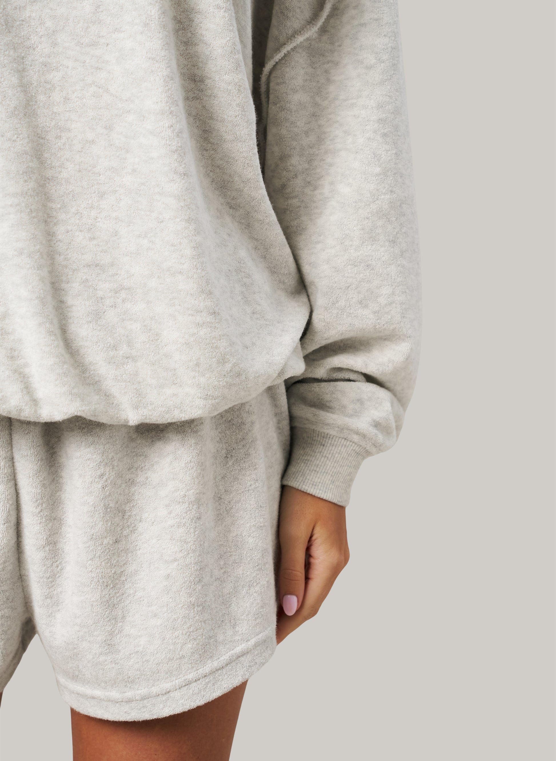 Grey sweatshirt and shorts set on a plain background