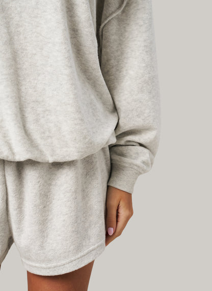 Grey sweatshirt and shorts set on a plain background