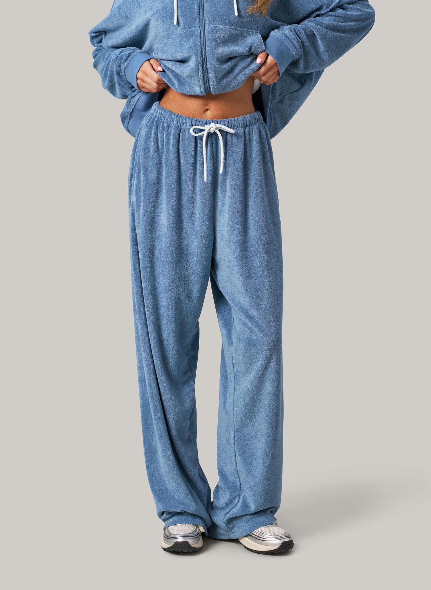 Light blue towelling tracksuit on light grey background