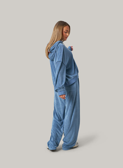 Person wearing a blue onesie against a grey background