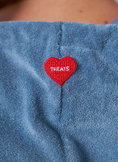Red heart-shaped patch with 'TREATS' text on a blue fabric background