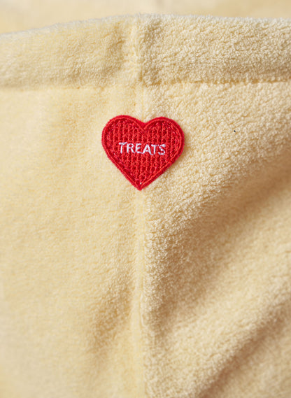 Red heart-shaped patch with 'TREATS' text on lemon fleece fabric