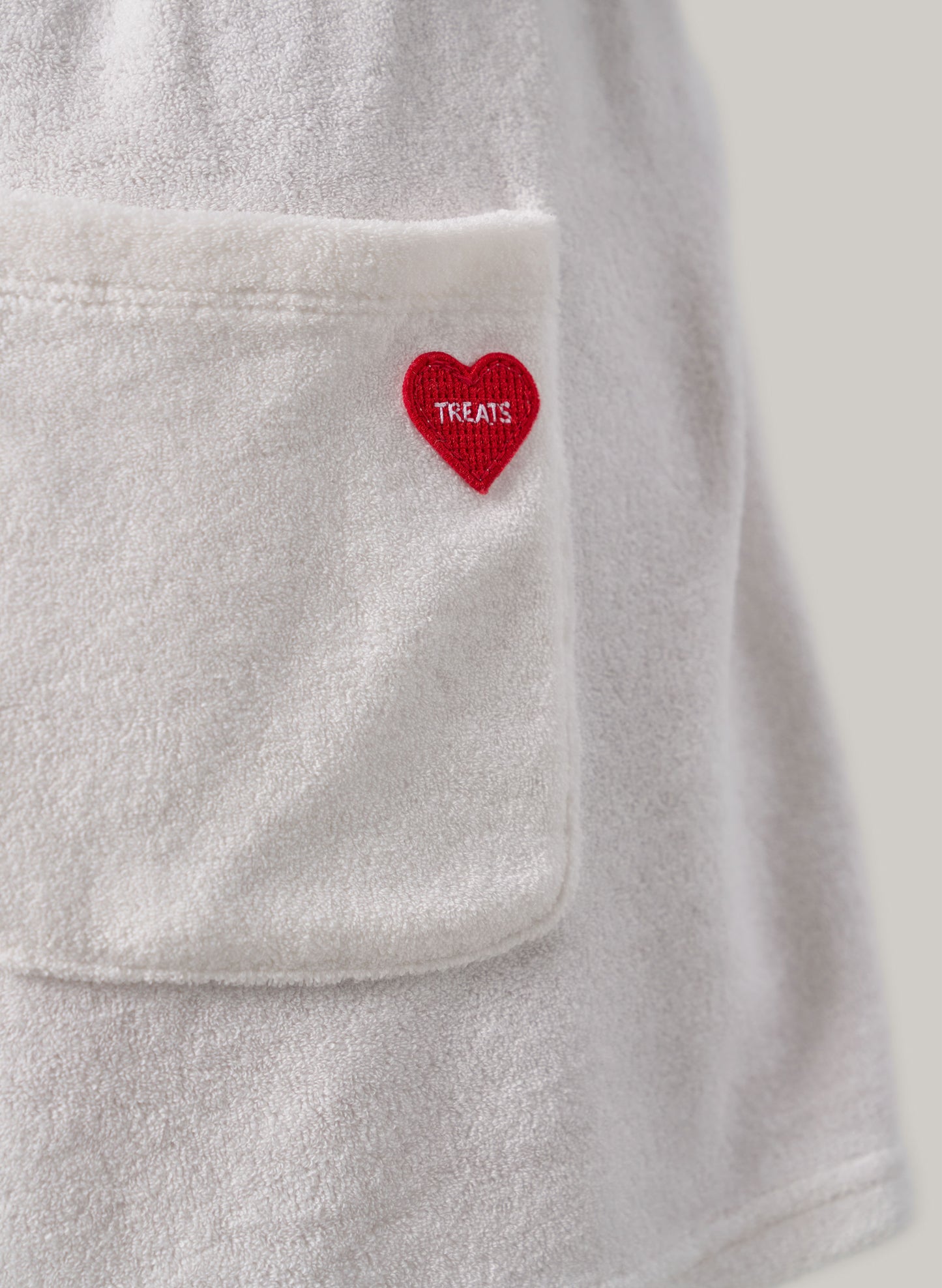 Grey Towel jacket with a red heart patch labeled 'TREATS' on a light grey background
