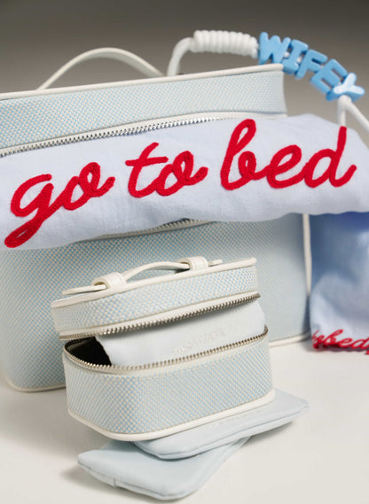 Light blue bag with 'go to bed' text and a smaller matching pouch on a neutral background
