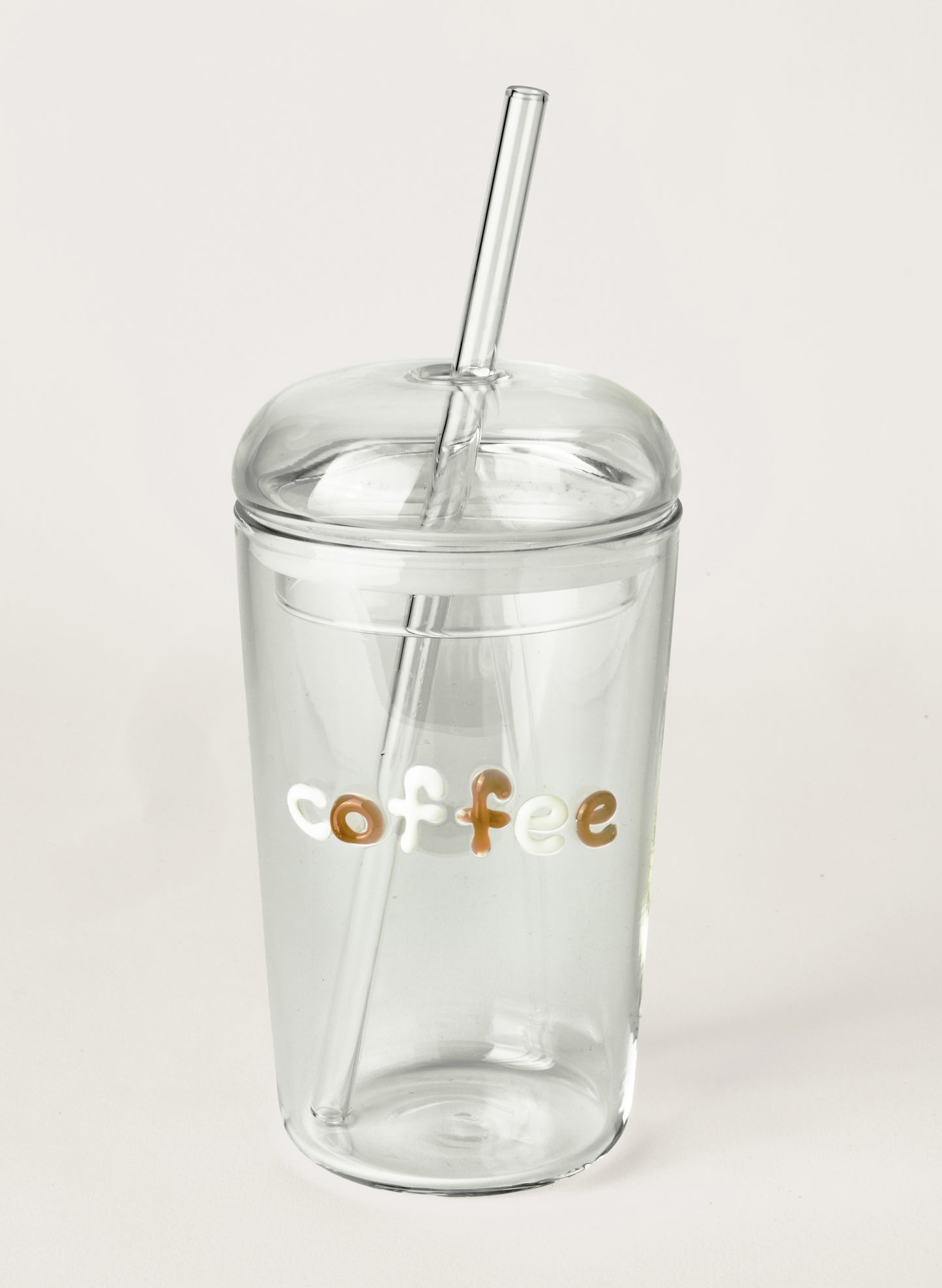 Clear glass tumbler with a straw and 'coffee' text on a light grey background