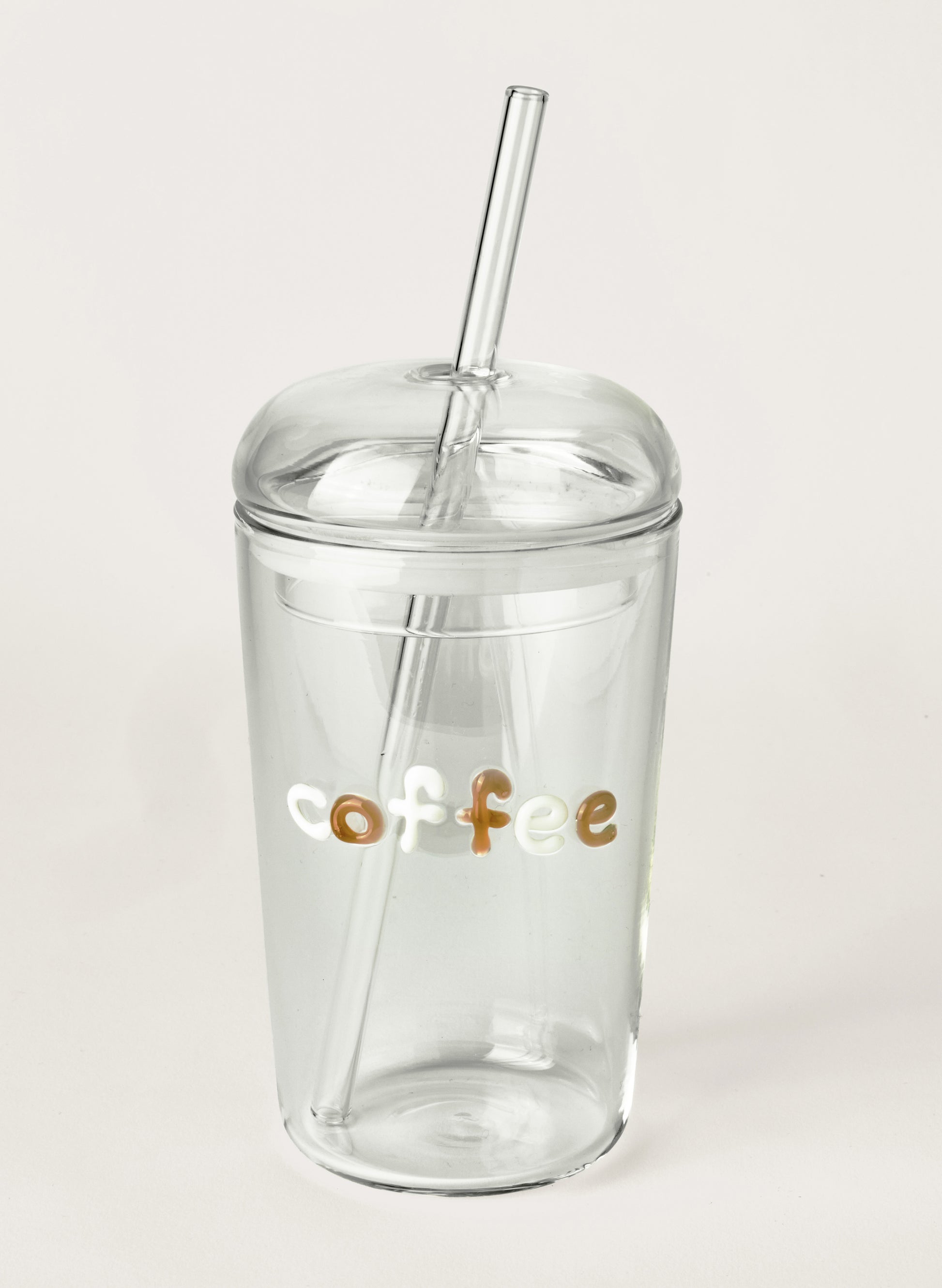 Clear glass tumbler with a straw and 'coffee' text on a light grey background
