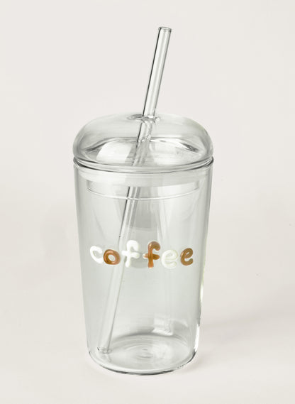 Clear glass tumbler with a straw and 'coffee' text on a light grey background
