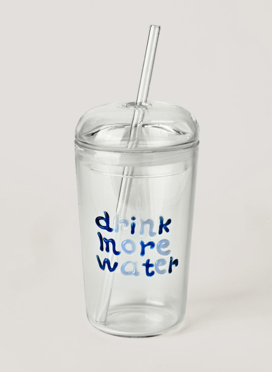 Glass tumbler with straw, with blue text 'drink more water' on a white background