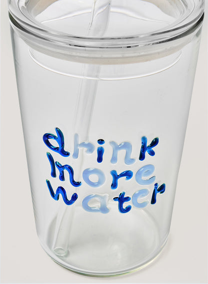 Glass tumbler with blue text 'drink more water' on a white background