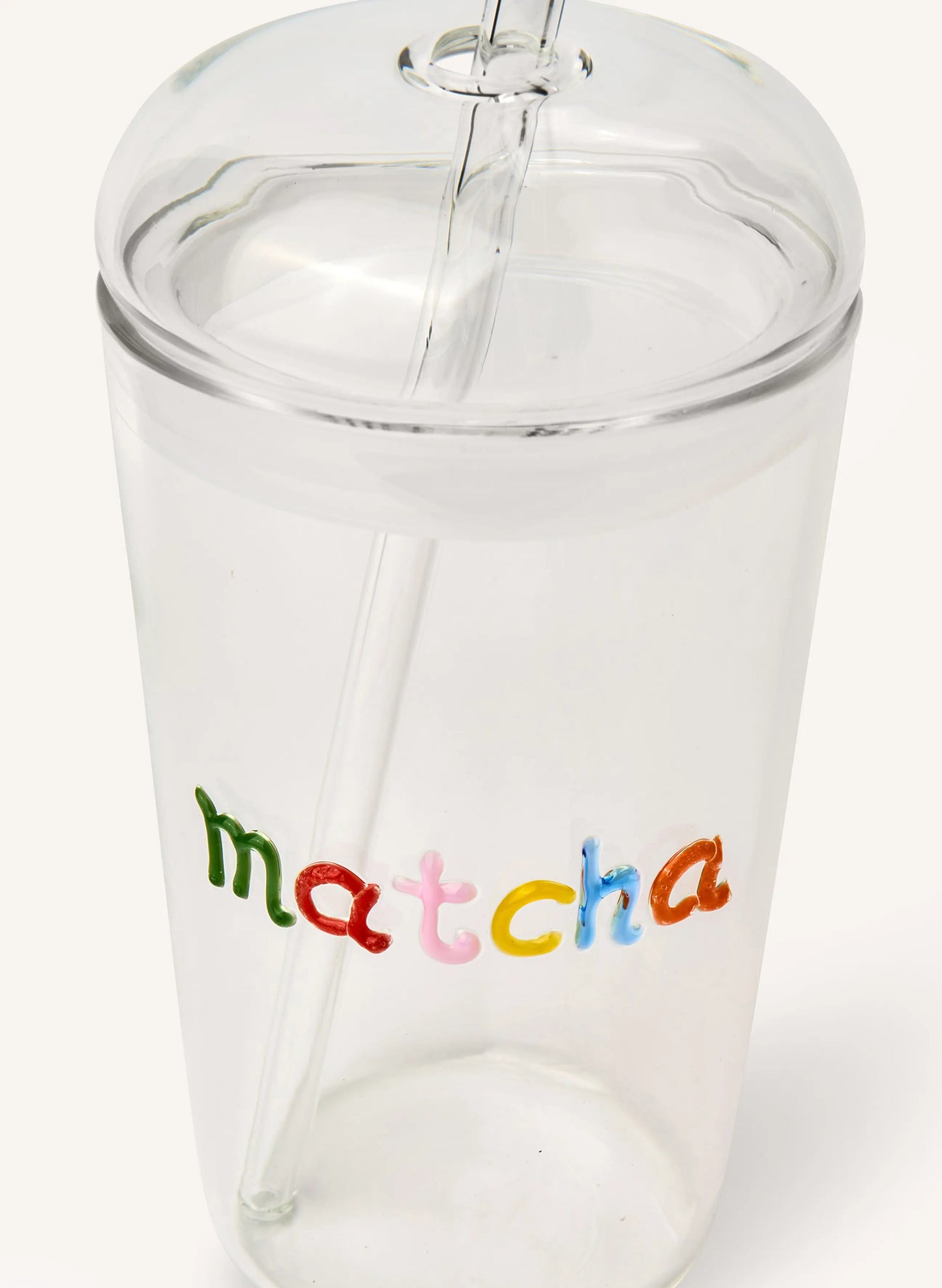 A clear glass tumbler with a matching clear lid and straw, featuring the word 'matcha' printed on the front in colorful lowercase letters.