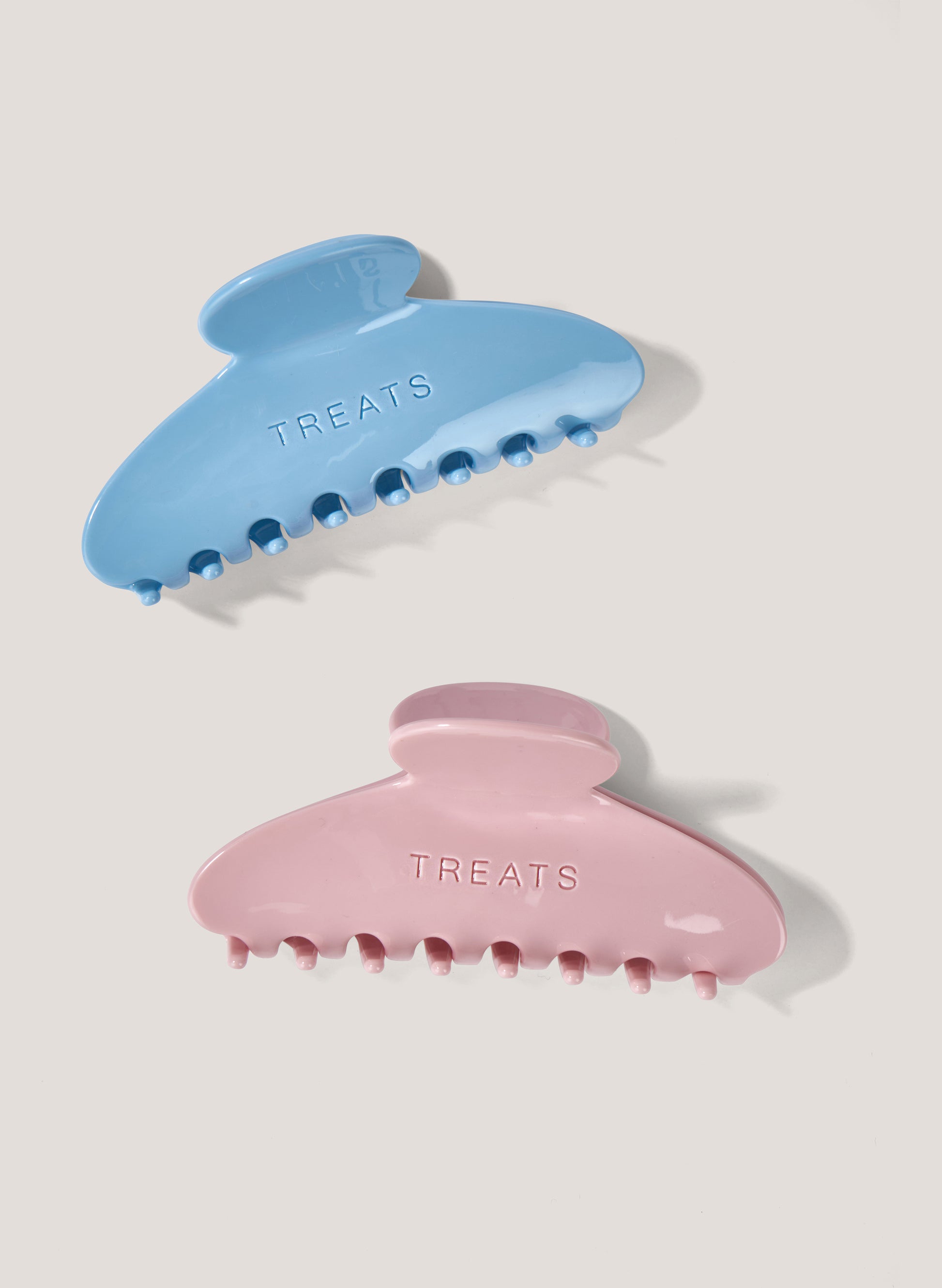 Two claw clips, one blue and one pink, on a white background.