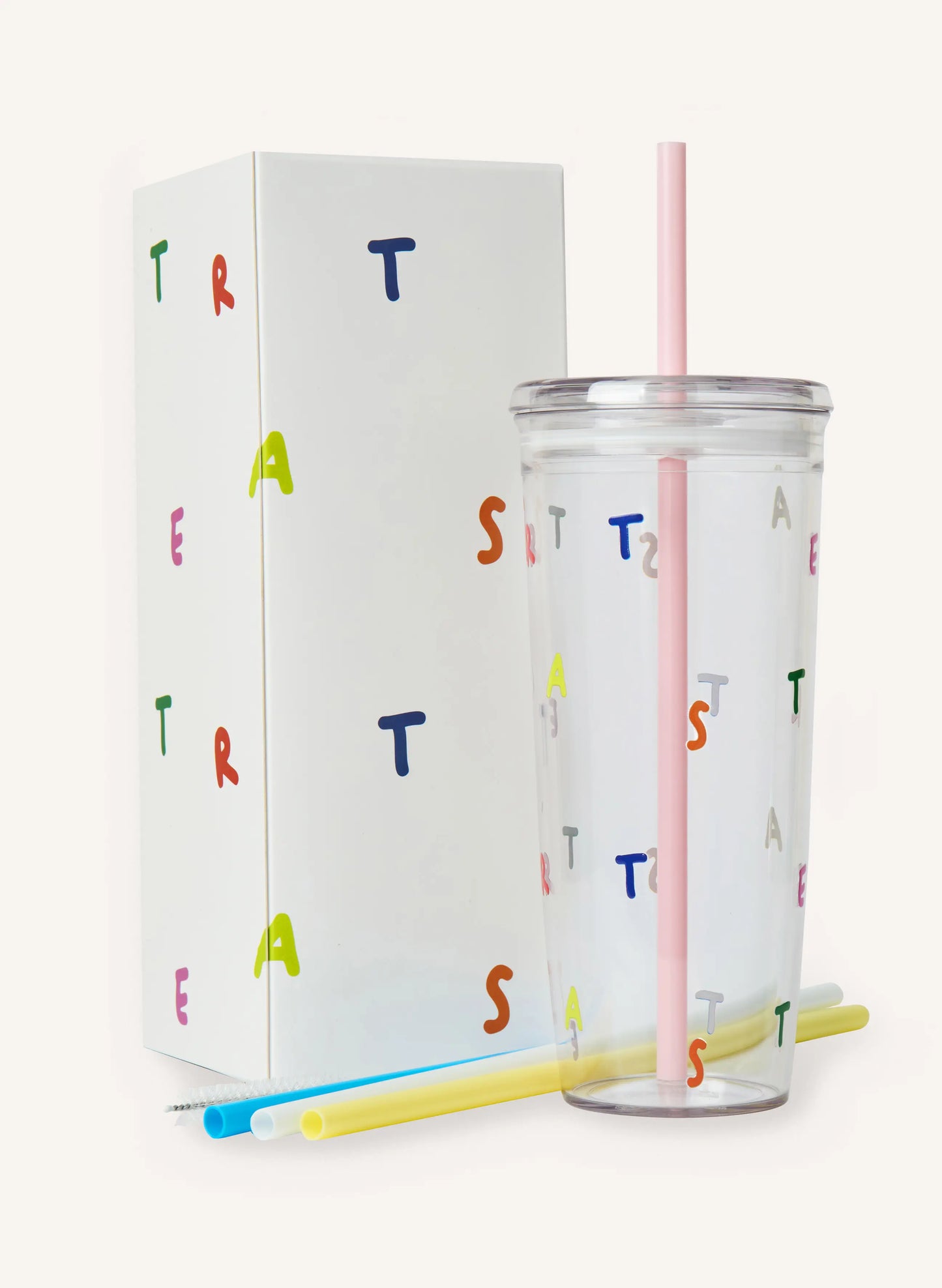 A clear tumbler with a pink straw against a solid off-white background.