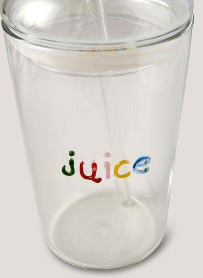 Clear tumbler with 'juice' text in colorful letters being filled with a white liquid.